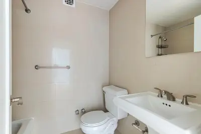 a white bathroom with a toilet and a sink at Blueground Murray Hill fitness center nr Bryant Park NYC-2171 in New York