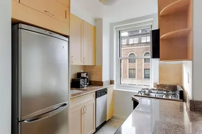 a kitchen with a stainless steel refrigerator and a window at Blueground Murray Hill fitness center nr Bryant Park NYC-2171 in New York