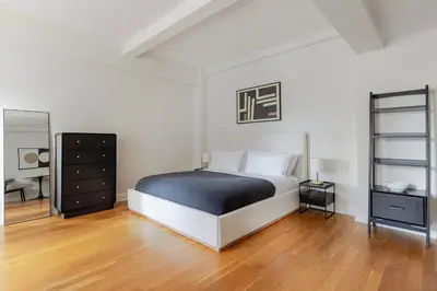 a bedroom with a bed and a dresser and a mirror at Blueground Murray Hill fitness center nr Bryant Park NYC-2171 in New York