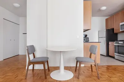 a kitchen with a white table and two chairs at Blueground Financial District rooftop nr Brooklyn Bridge NYC-2201 in New York