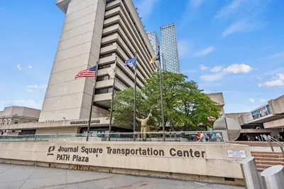 a building with a sign in front of it at Spacious Duplex only 15 Minutes to NYC with Firepit Perfect for Groups in Jersey City