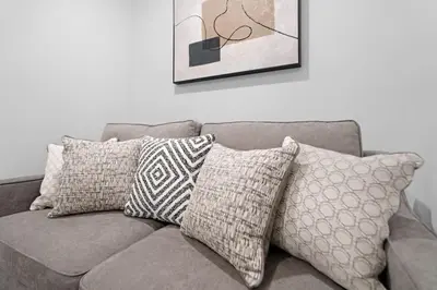 a couch with pillows on it in a living room at Spacious Duplex only 15 Minutes to NYC with Firepit Perfect for Groups in Jersey City