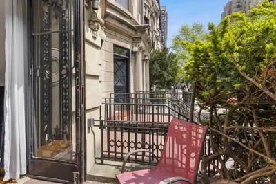 a red chair sitting on a balcony of a building at Stylish Studio in Central Park in Best Location Ever in New York
