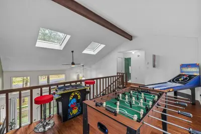 a living room with a foosball table and agamuitous at Pocono Serenity Retreat | 3-BR w/ Bonus King Suite & Hot Tub by Stay Lage in East Stroudsburg