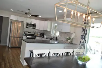 a kitchen with white cabinets and a table with chairs at County Peace with Luxurious Amenities