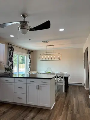 a kitchen with white cabinets and a ceiling fan at County Peace with Luxurious Amenities