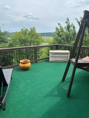 a balcony with a green floor and a wooden railing at Private oasis near Lititz in Lancaster