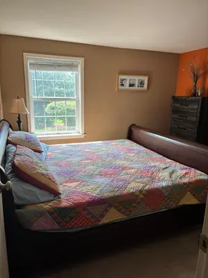 a bedroom with a bed with a colorful comforter and a window at Private oasis near Lititz in Lancaster