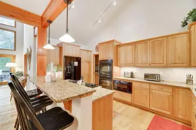 a large kitchen with wooden cabinets and a counter top at Spacious Lake Front Winter Retreat! Less than 10 Min to Big Boulder! in Blakeslee