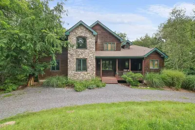 a home with a stone and wood at Spacious Lake Front Winter Retreat! Less than 10 Min to Big Boulder! in Blakeslee