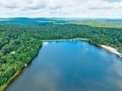 an aerial view of a large lake with a beach at Spacious Lake Front Winter Retreat! Less than 10 Min to Big Boulder! in Blakeslee