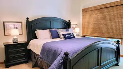 a bedroom with a large bed with a blue headboard at Spacious Lake Front Winter Retreat! Less than 10 Min to Big Boulder! in Blakeslee