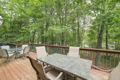 a patio with a table and chairs on a deck at Spacious Lake Front Winter Retreat! Less than 10 Min to Big Boulder! in Blakeslee