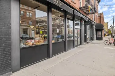 a row of store windows on a city street at Luxury Brand New 3BED Gem 20 Minutes to NYC in Jersey City