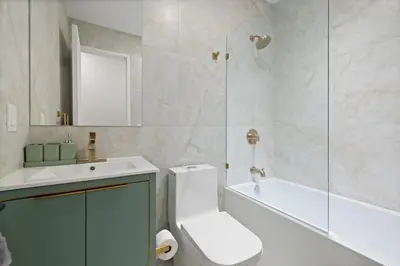 a bathroom with a toilet and a sink and a shower at Luxury and Trendy 3BR 2BA APT only 20 minutes to New York in Jersey City