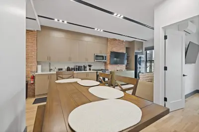 a kitchen with a wooden table and a kitchen with a counter at New Luxury and Chic 3BR 2BA Apartment 20 Minutes to NYC in Jersey City