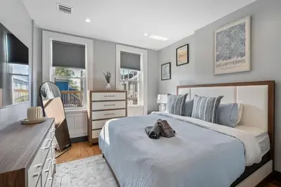 a bedroom with a large bed with a bag on it at Luxury and Modern Apt with Patio only 10 Min to Times Square in Jersey City