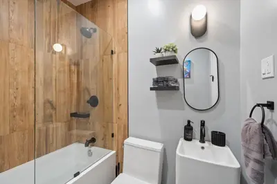 a bathroom with a toilet and a sink and a mirror at Luxury and Modern Apt with Patio only 10 Min to Times Square in Jersey City