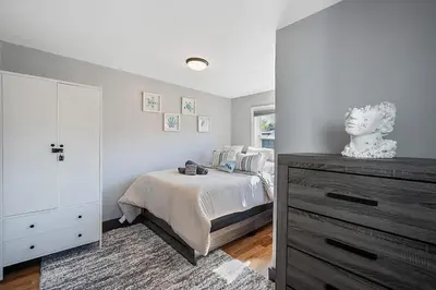 a white bedroom with a bed and a dresser at Luxury and Modern Apt with Patio only 10 Min to Times Square in Jersey City