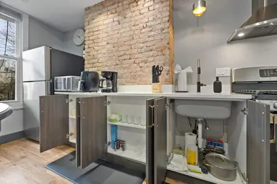 a kitchen with a counter and a brick wall at Luxury and Chic 2BR 2BA Apt only 15 Mins to NYC & Hoboken in Jersey City