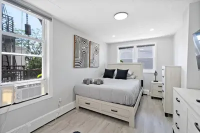 a white bedroom with a bed and a window at New and Beautiful 2BR Apt in Prime Spot 20 Min to NYC in Jersey City