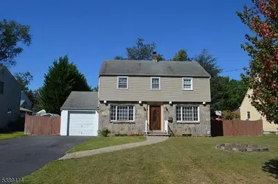 a brick house with a garage in a yard at Single Family Homes Dunelle in Dunellen