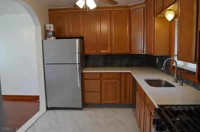 a kitchen with a white refrigerator and wooden cabinets at Single Family Homes Dunelle in Dunellen