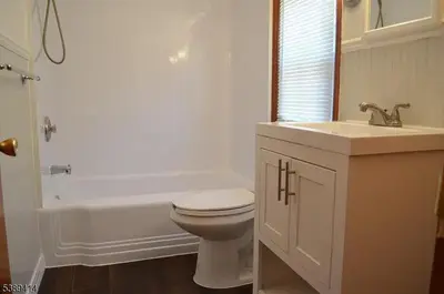 a white bathroom with a toilet and a sink at Single Family Homes Dunelle in Dunellen