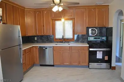 a kitchen with wooden cabinets and a stainless steel refrigerator at Single Family Homes Dunelle in Dunellen
