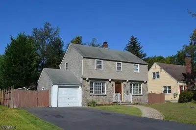 a gray house with a white garage at Single Family Homes Dunelle in Dunellen
