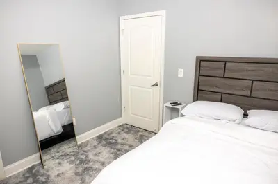a bedroom with a white bed and a mirror at Airende in Newark