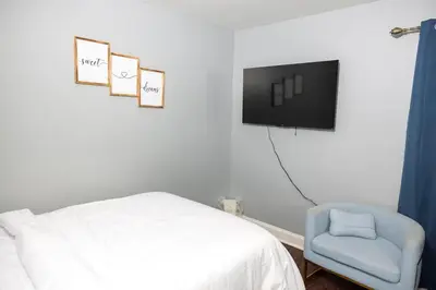 a bedroom with a bed and a tv and a chair at Airende in Newark