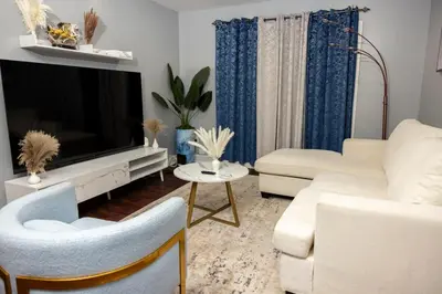 a living room with a white couch and a large television at Airende in Newark