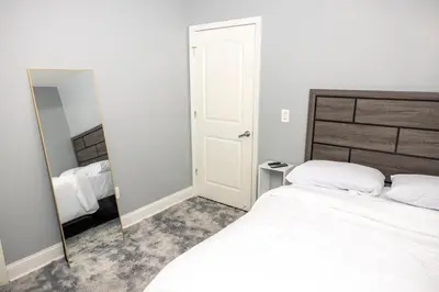 a bedroom with a white bed and a mirror at Airende in Newark