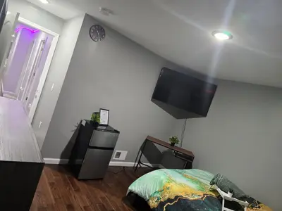 a bedroom with a bed and a flat screen tv at Cozy 3-Bedroom Apartment in Newark near NYC in Newark