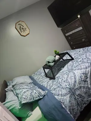 a bedroom with a bed with a table on it at Cozy 3-Bedroom Apartment in Newark near NYC in Newark