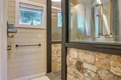 a bathroom with a shower and a sink at Lakefront Cottage with Dock, Hot Tub and Fire Pit in Greentown