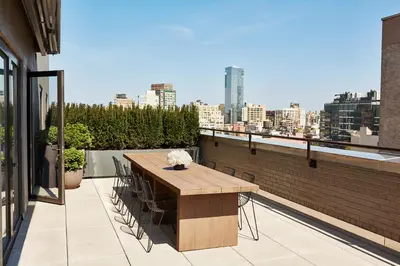 a wooden table on a balcony with a view of a city at 11 Howard, New York, a Member of Design Hotels in New York