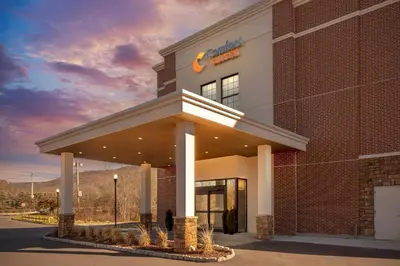 a building with a sign on the front of it at Comfort Suites Central Valley - Woodbury in Central Valley