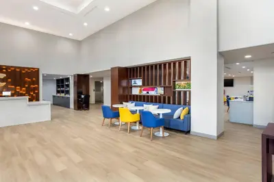 a lobby with a table and chairs and a kitchen at Comfort Suites Central Valley - Woodbury in Central Valley
