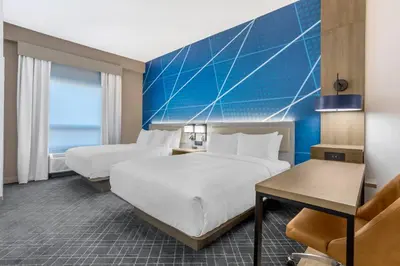 a hotel room with two beds and a blue wall at Comfort Suites Central Valley - Woodbury in Central Valley