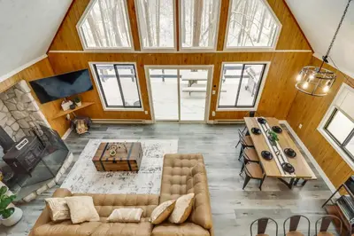 a living room with a couch and a table at Scenic Views! Clifton Twp Chalet with Fire Pit, Deck in Gouldsboro