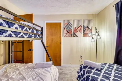 a bedroom with a bunk bed next to a door at Scenic Views! Clifton Twp Chalet with Fire Pit, Deck in Gouldsboro