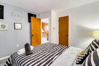 a bedroom with a bed with a black and white comforter at Scenic Views! Clifton Twp Chalet with Fire Pit, Deck in Gouldsboro