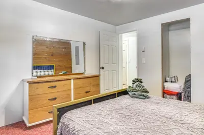 a bedroom with a large bed and a dresser at Pool, Beach and Lake Access Poconos Cabin Escape! in Tobyhanna