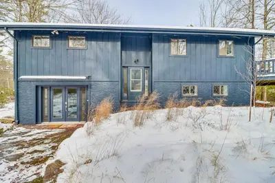a blue house with snow in front of it at Vibrant Hideaway on Shores of West Emerald Lake! in Long Pond