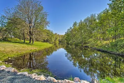 a river in the middle of a field with trees at Vibrant Hideaway on Shores of West Emerald Lake! in Long Pond