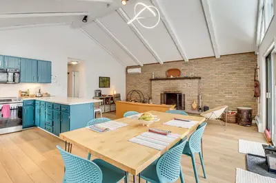 a kitchen and dining room with a wooden table and chairs at Vibrant Hideaway on Shores of West Emerald Lake! in Long Pond