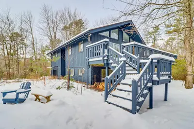 a blue house with stairs in the snow at Vibrant Hideaway on Shores of West Emerald Lake! in Long Pond