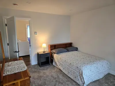 a bedroom with two beds and a lamp on a table at Just Like Home, Overlooks Maple Grove Raceway in Mohnton